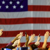 American flag with people raising their hands